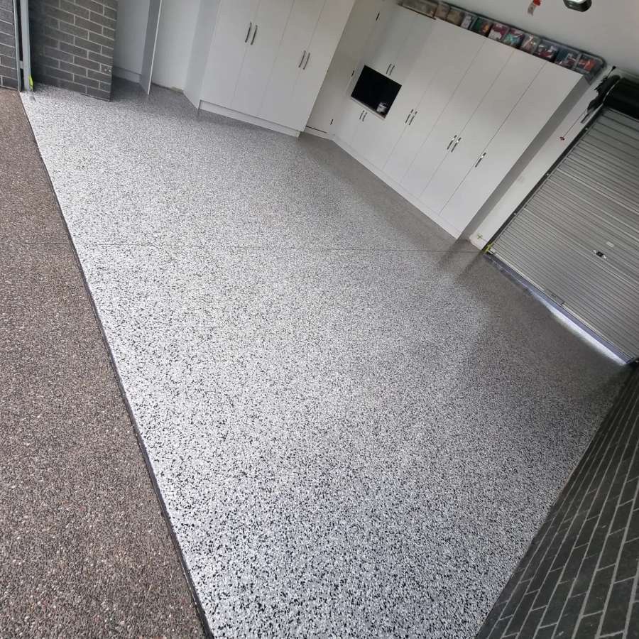 Garage concrete slab before epoxy resurfacing, showing surface wear and stains