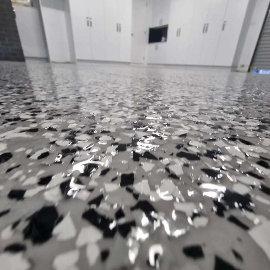 Wide view of the completed epoxy floor across the garage with neat edge finishing