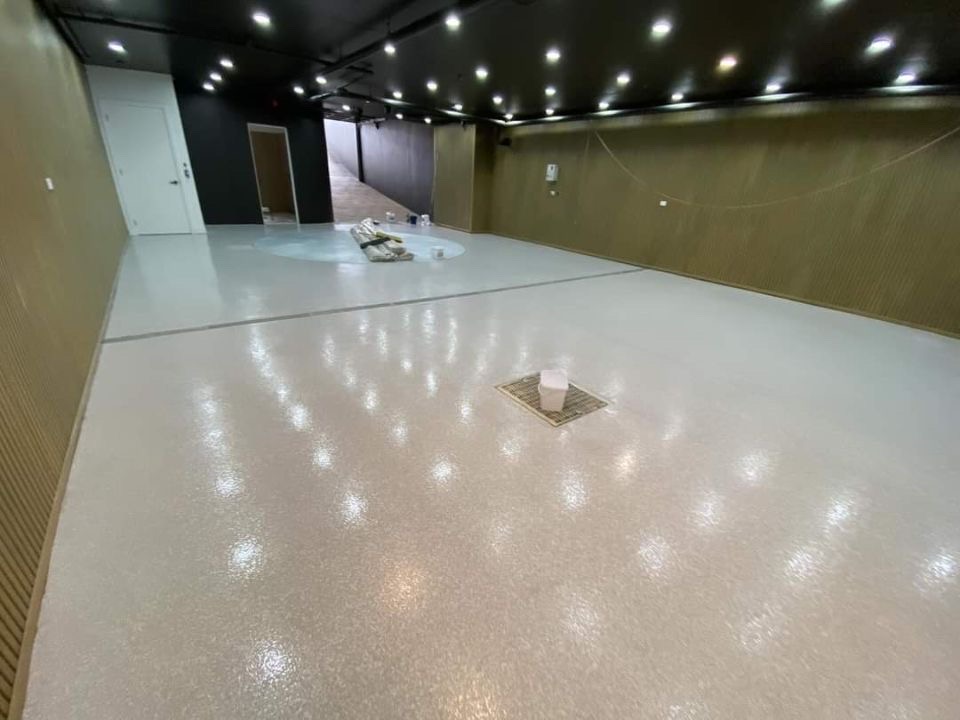 Wide view of the completed epoxy floor across the space with neat edge finishing