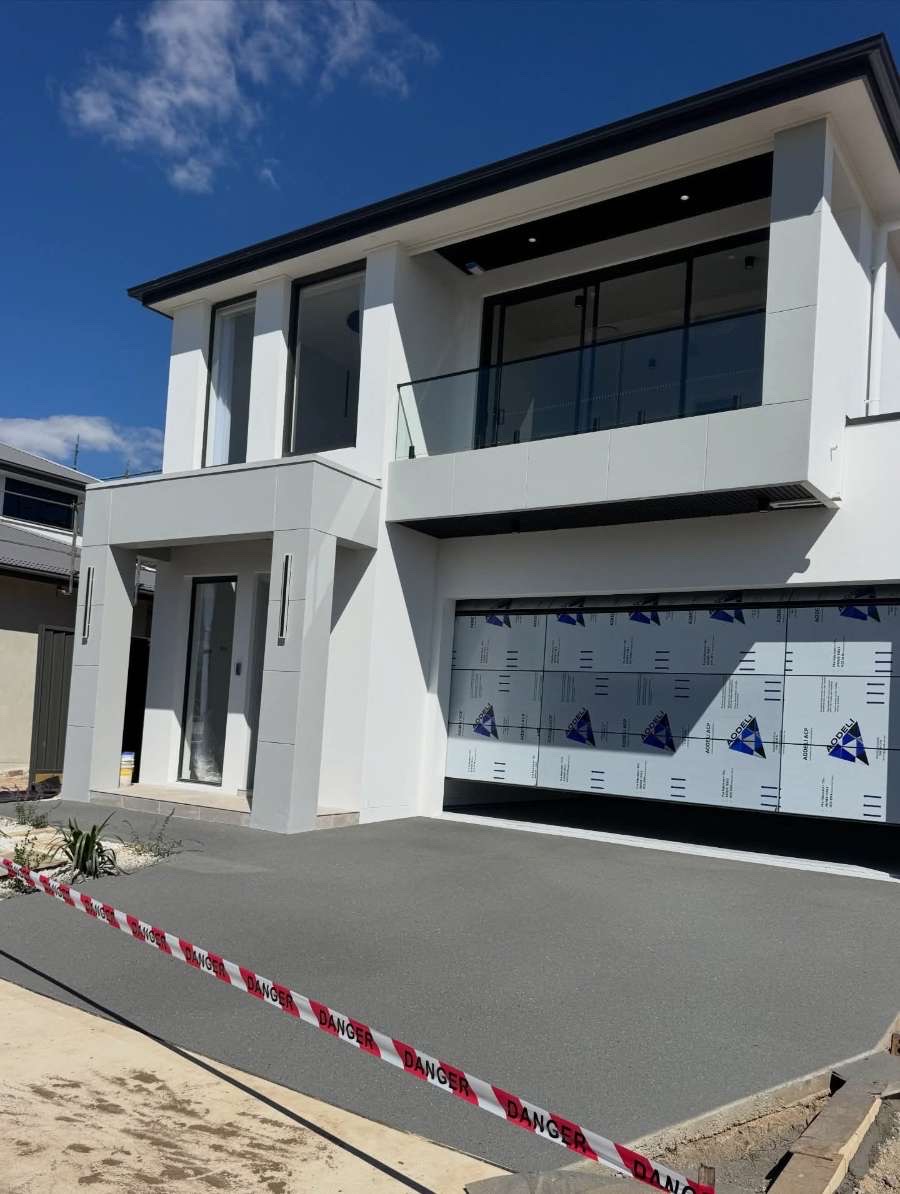 Modern Brighton home with protective sheeting and tape during concrete resurfacing preparation