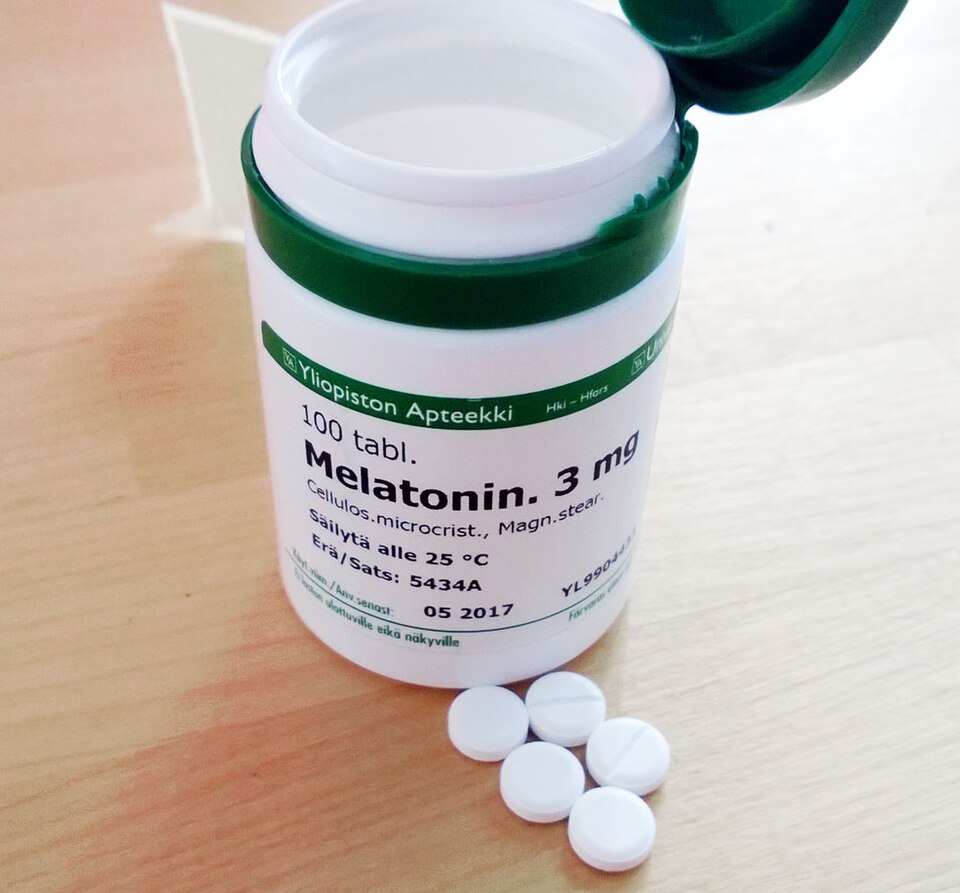 Bottle of melatonin tablets used as a sleep aid to help travelers adjust to jet lag on long international flights.