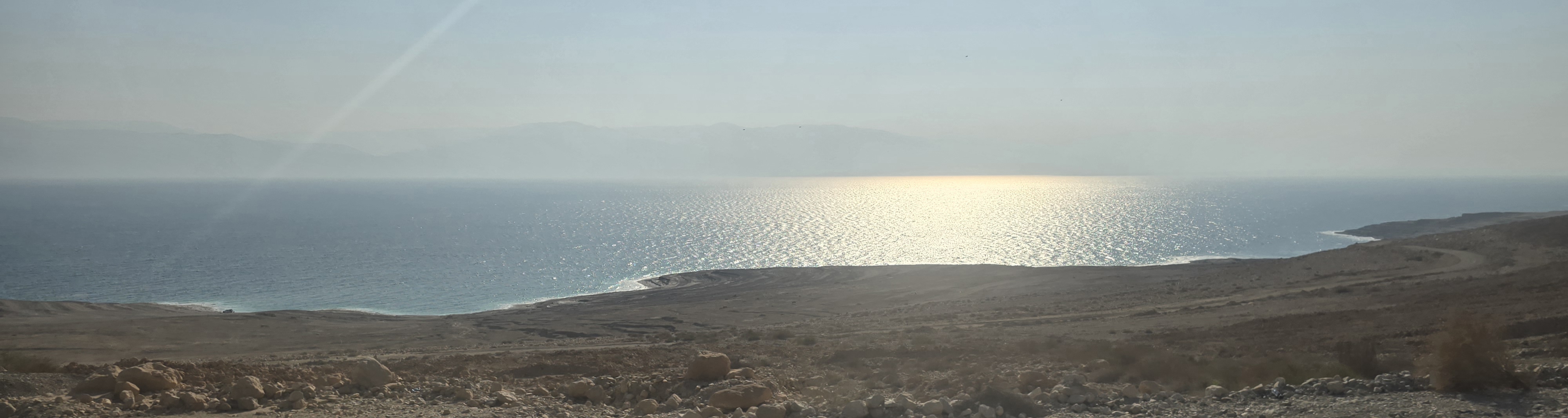 Desert hills overlooking the Red Sea near Eilat, Israel, with rocky terrain and coastal road under bright sunlight.