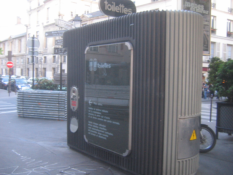 Automated public pay toilet in Paris street, illustrating paid restroom facilities common in European cities. Automated public pay toilet in Paris street, illustrating paid restroom facilities common in European cities.