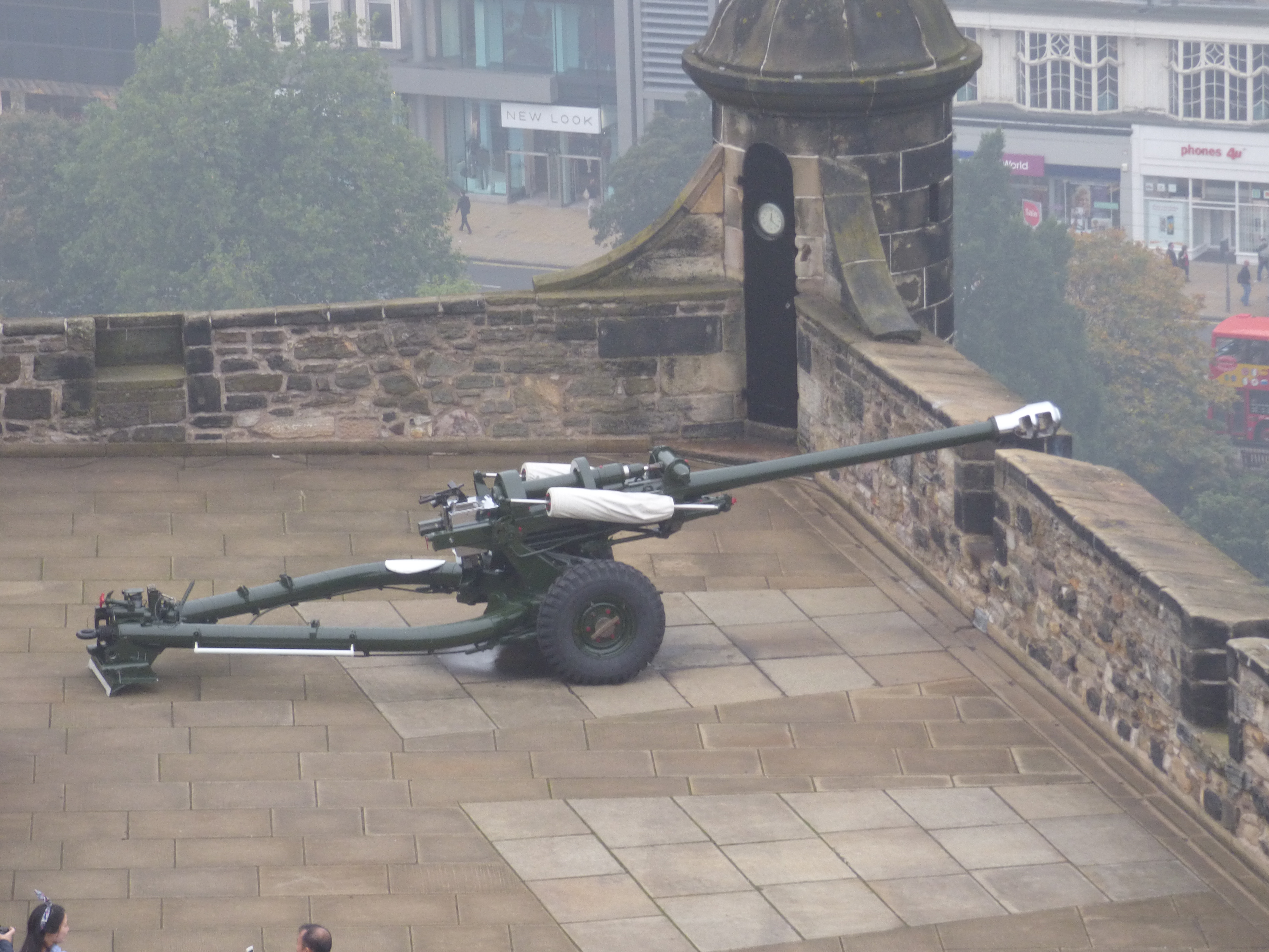 Artillery gun on Edinburgh Castle walls overlooking modern city streets, illustrating historic military structures integrated into daily urban life. Artillery gun on Edinburgh Castle walls overlooking modern city streets, illustrating historic military structures integrated into daily urban life.