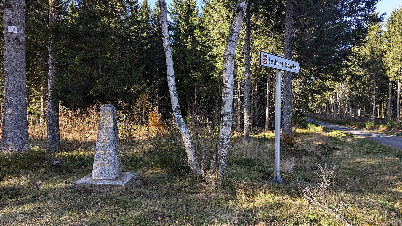Memorial stele marking the Battle of Mont Mouchet beside a forest road with sign for Mont Mouchet, commemorating Maquis resistance fighters during World War II. Memorial stele marking the Battle of Mont Mouchet beside a forest road with sign for Mont Mouchet, commemorating Maquis resistance fighters during World War II.