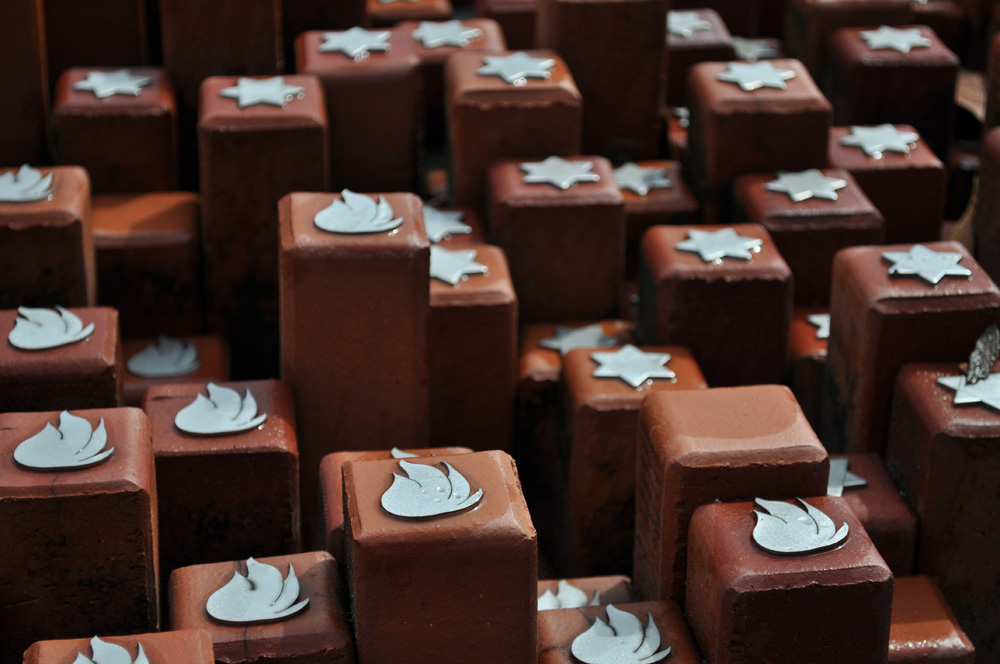 Close-up of symbolic brick markers with Star of David and flame emblems at the memorial site of Westerbork Transit Camp Memorial, commemorating Jewish victims deported during the Holocaust. Close-up of symbolic brick markers with Star of David and flame emblems at the memorial site of Westerbork Transit Camp Memorial, commemorating Jewish victims deported during the Holocaust.