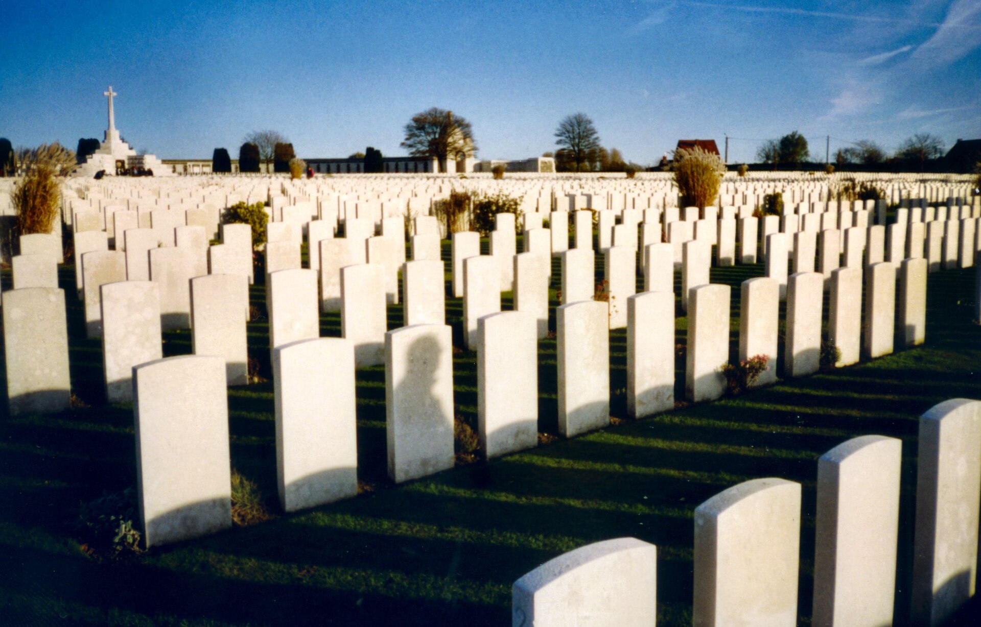 Rows of headstones at Tyne Cot Commonwealth War Graves Commission Cemetery in Flanders, Belgium, at dusk.