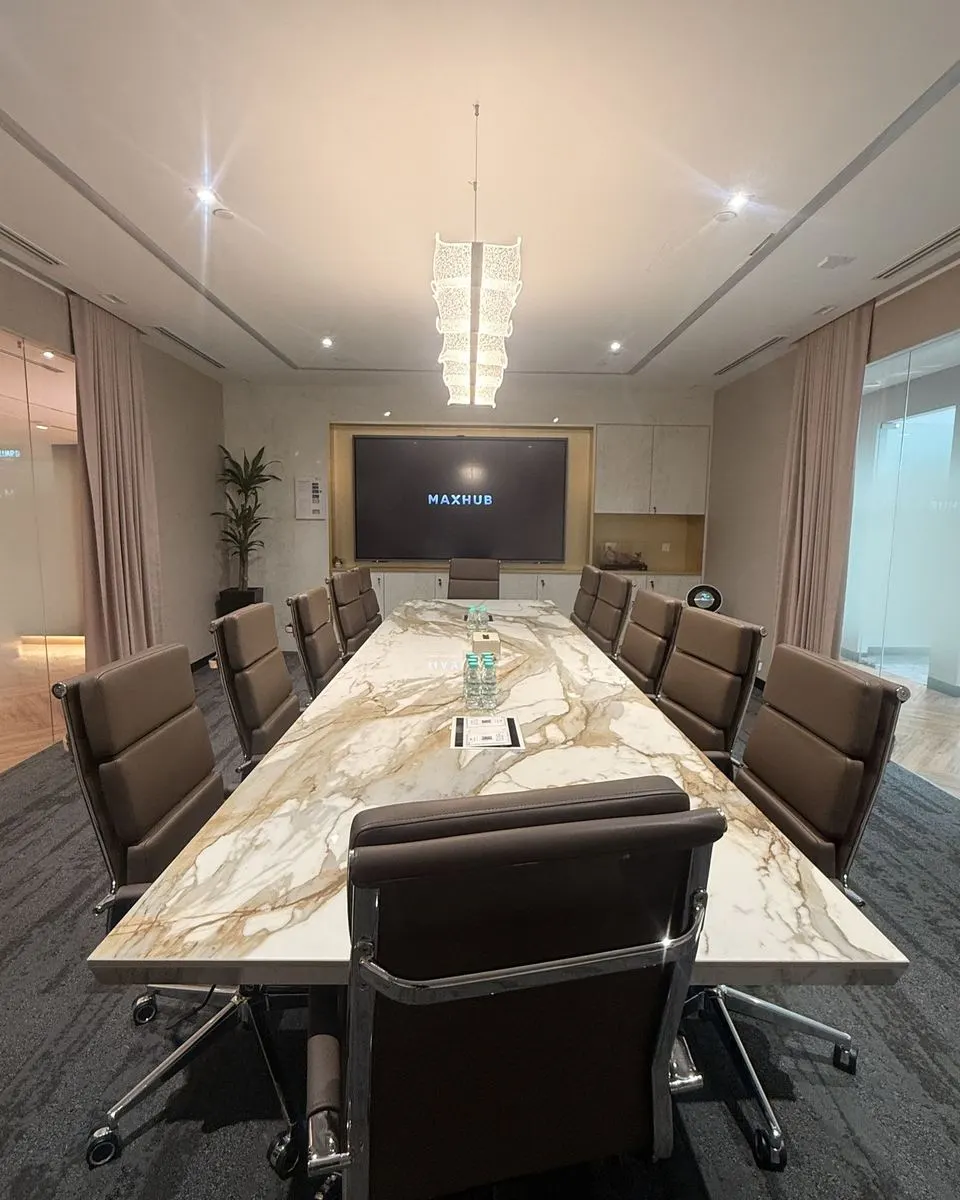 Marble-table boardroom with a wall-mounted panel