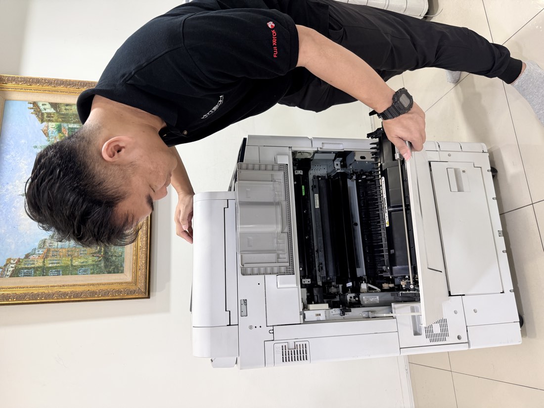 Hytech technician servicing a copier on-site