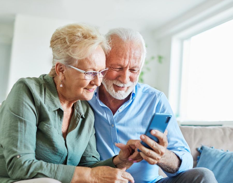 An older couple smiling at a phone