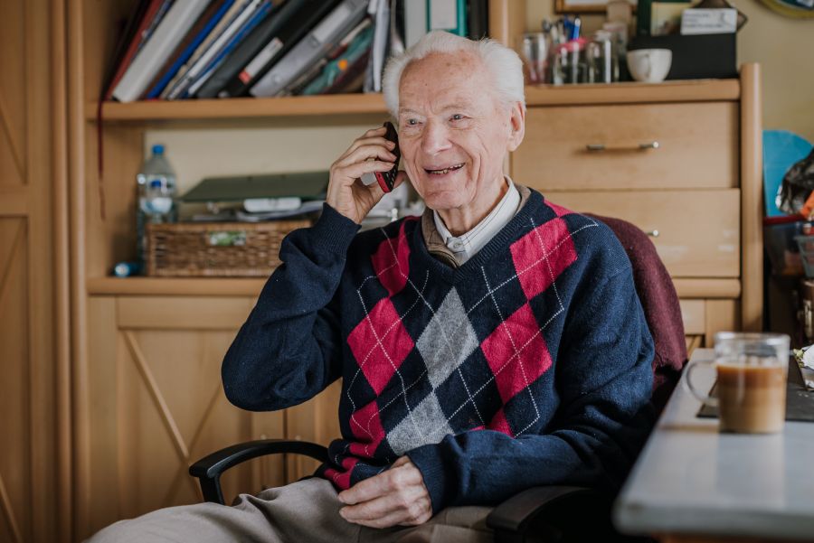 An older man speaking on the telephone