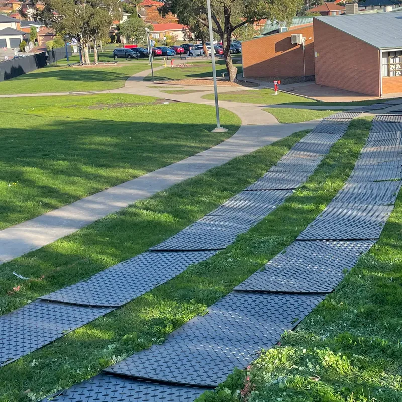 Ground protection mats laid across soft ground to carry vehicle loads