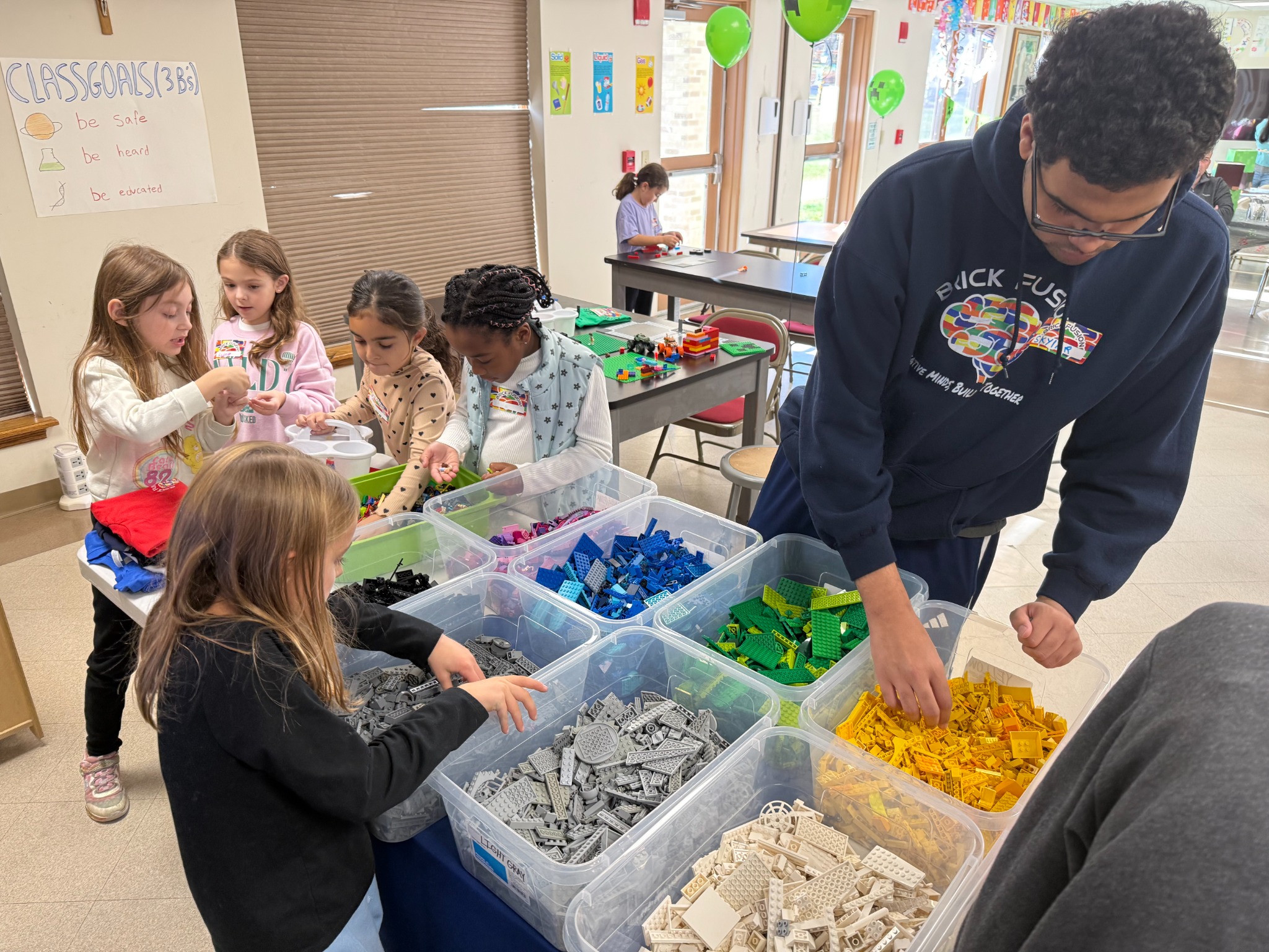 An instructor and children choosing bricks for their birthday builds