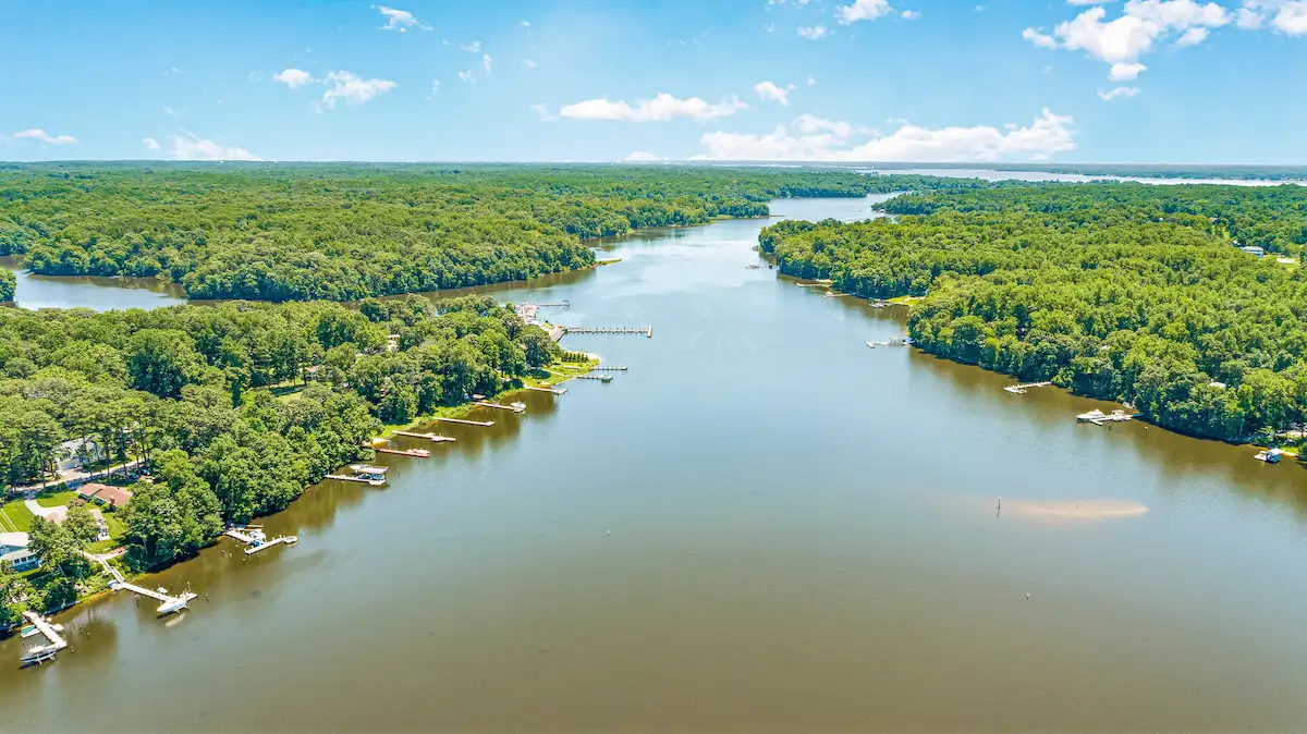 Aerial view of homes and private piers along a wooded creek in Southern Maryland