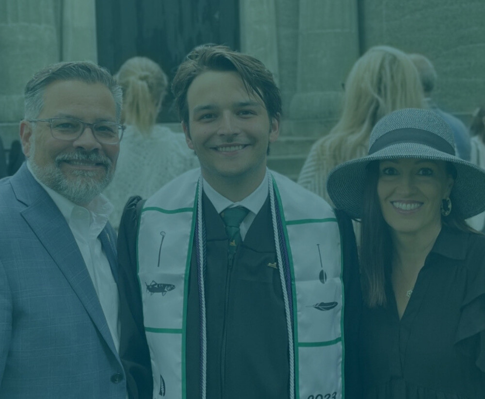 Male student with parents during graduation