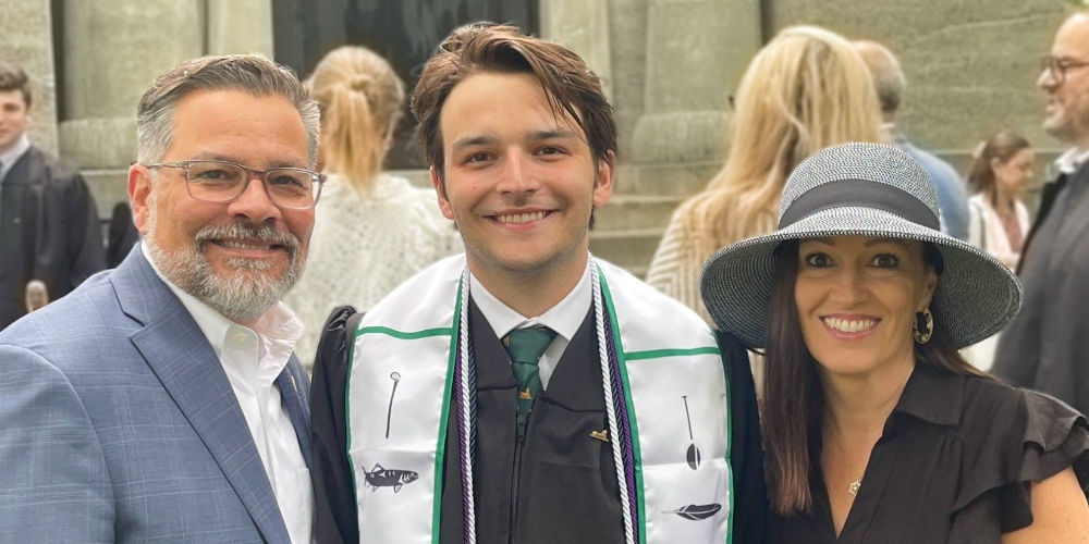 Male student with parents during graduation