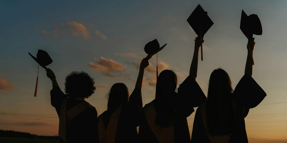 Graduates celebrating successful law and med school admissions at sunset
