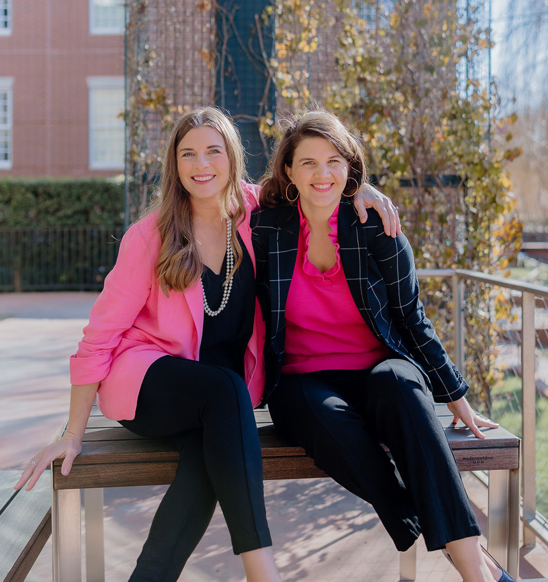 Autumn, CEO of Gradmissions, and Lizanne, VP of Client Success, sitting on campus bench