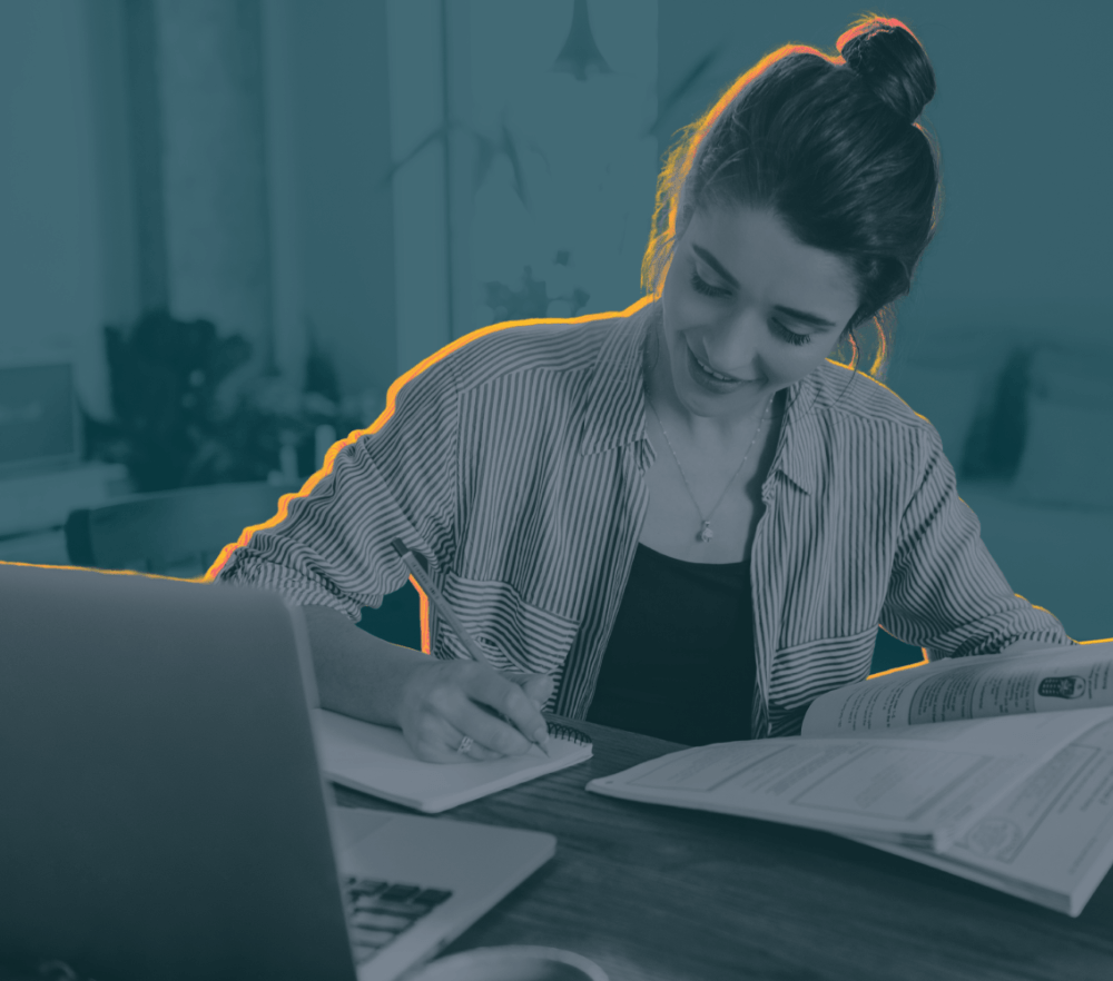 Female student writing an essay at her desk