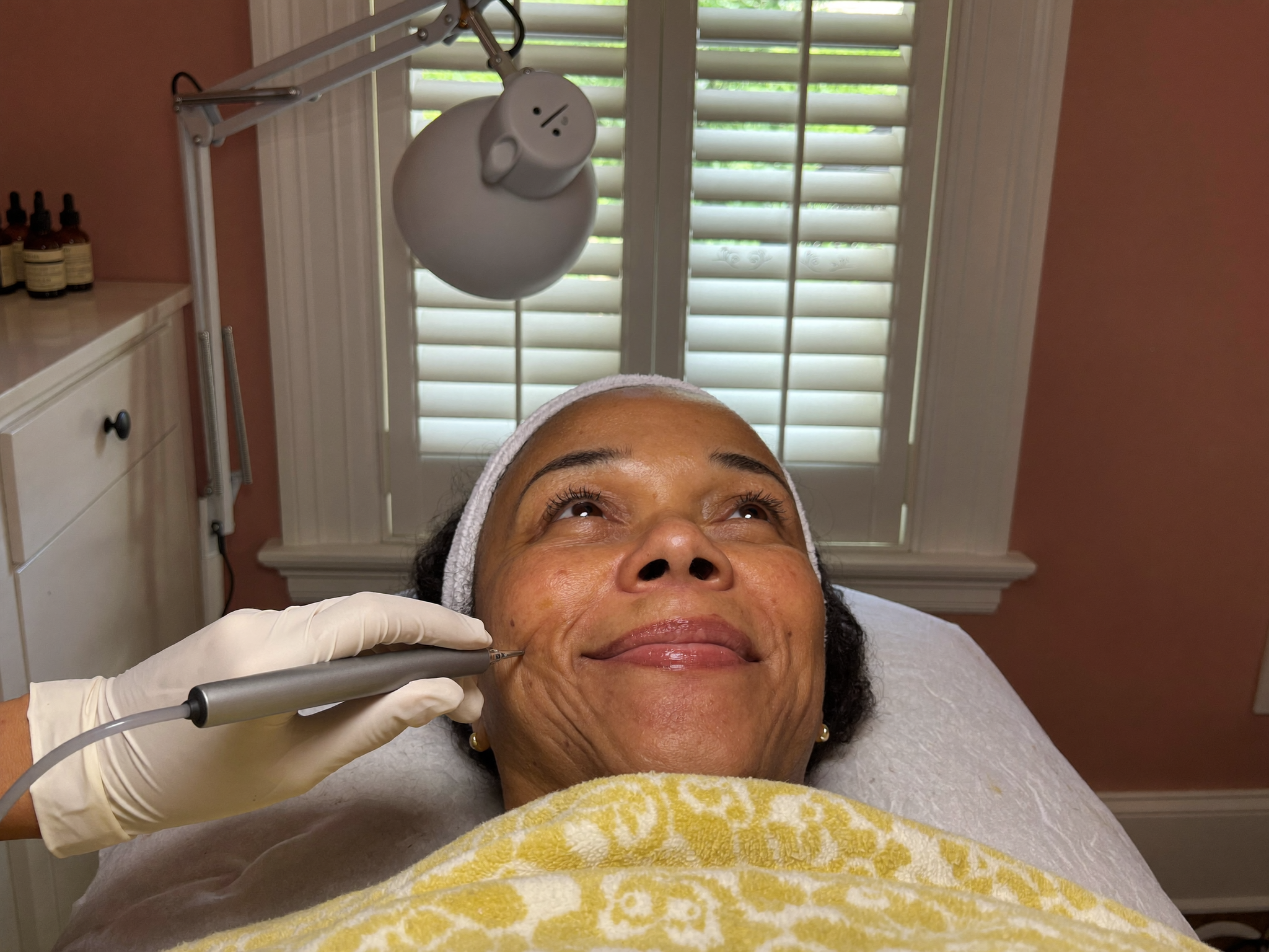 Esthetician using a microcurrent device during an anti-aging facial