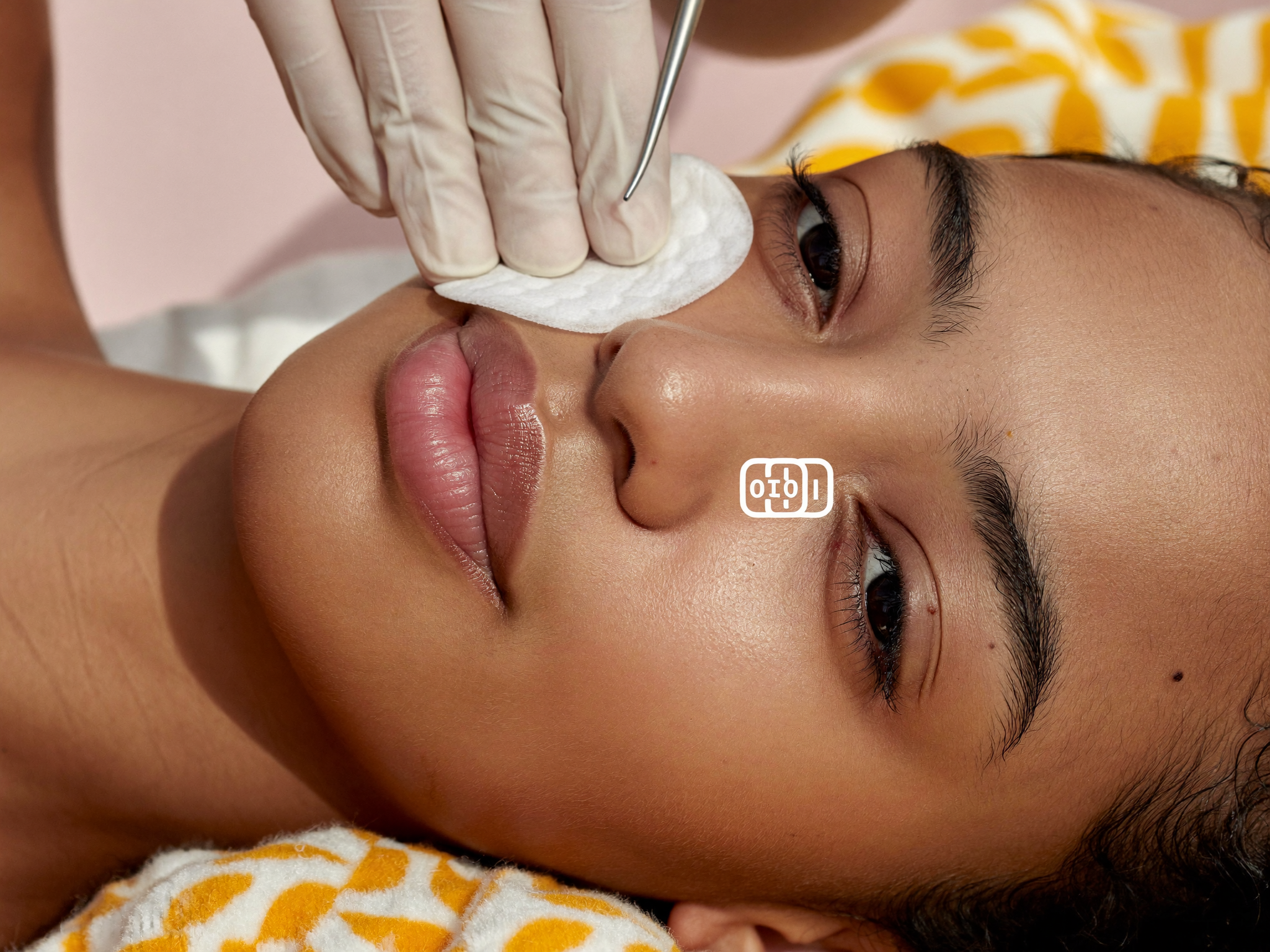 Esthetician cleansing a client’s skin during a deep pore facial