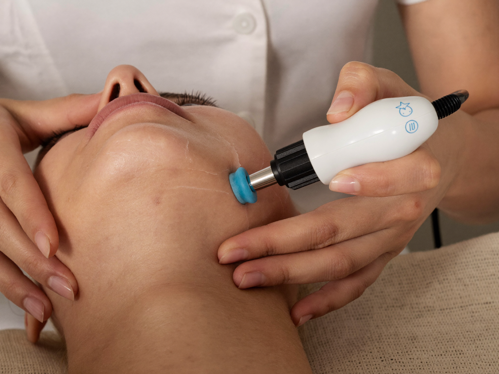 Esthetician using a microdermabrasion wand during a facial