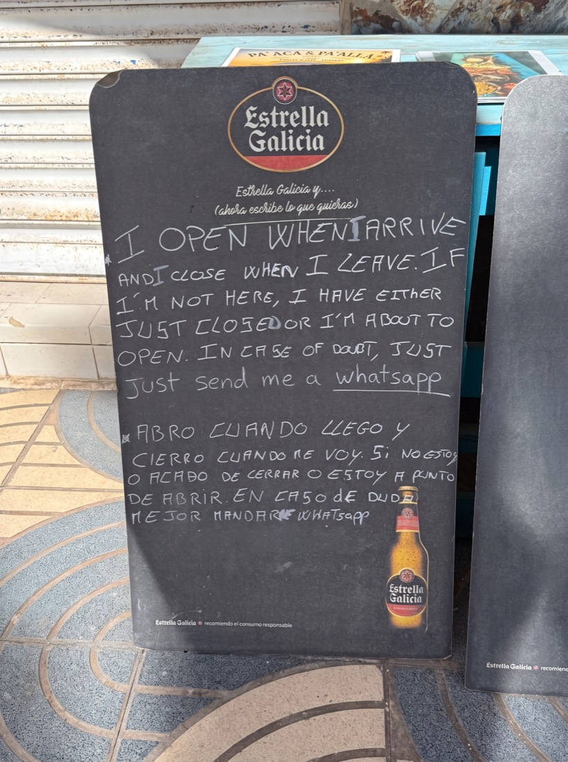 Krijtbord bij een strandtentje: I open when I arrive and I close when I leave