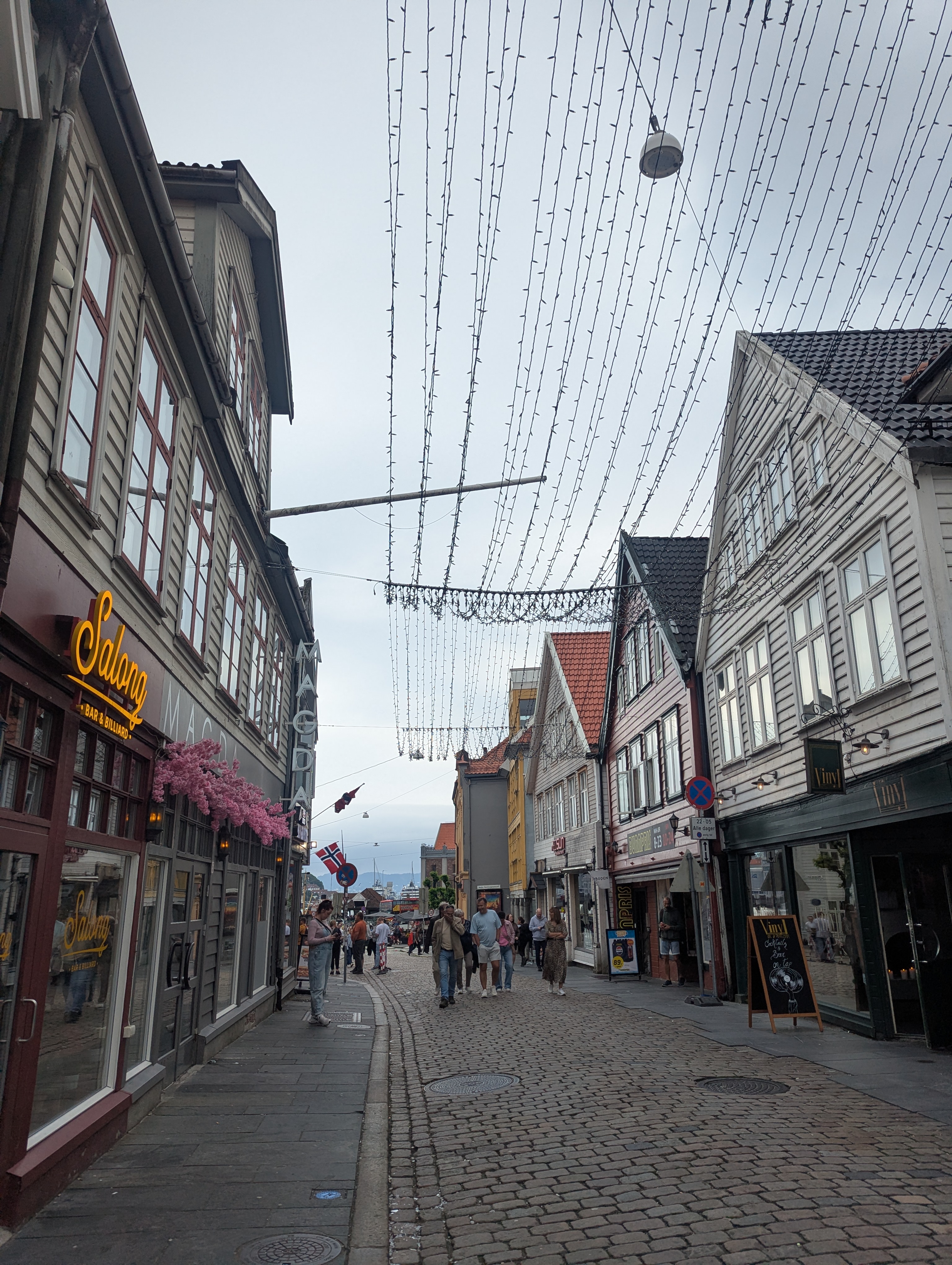 Bergen cobbletone street with hanging lights and pretty storefronts Bergen cobbletone street with hanging lights and pretty storefronts