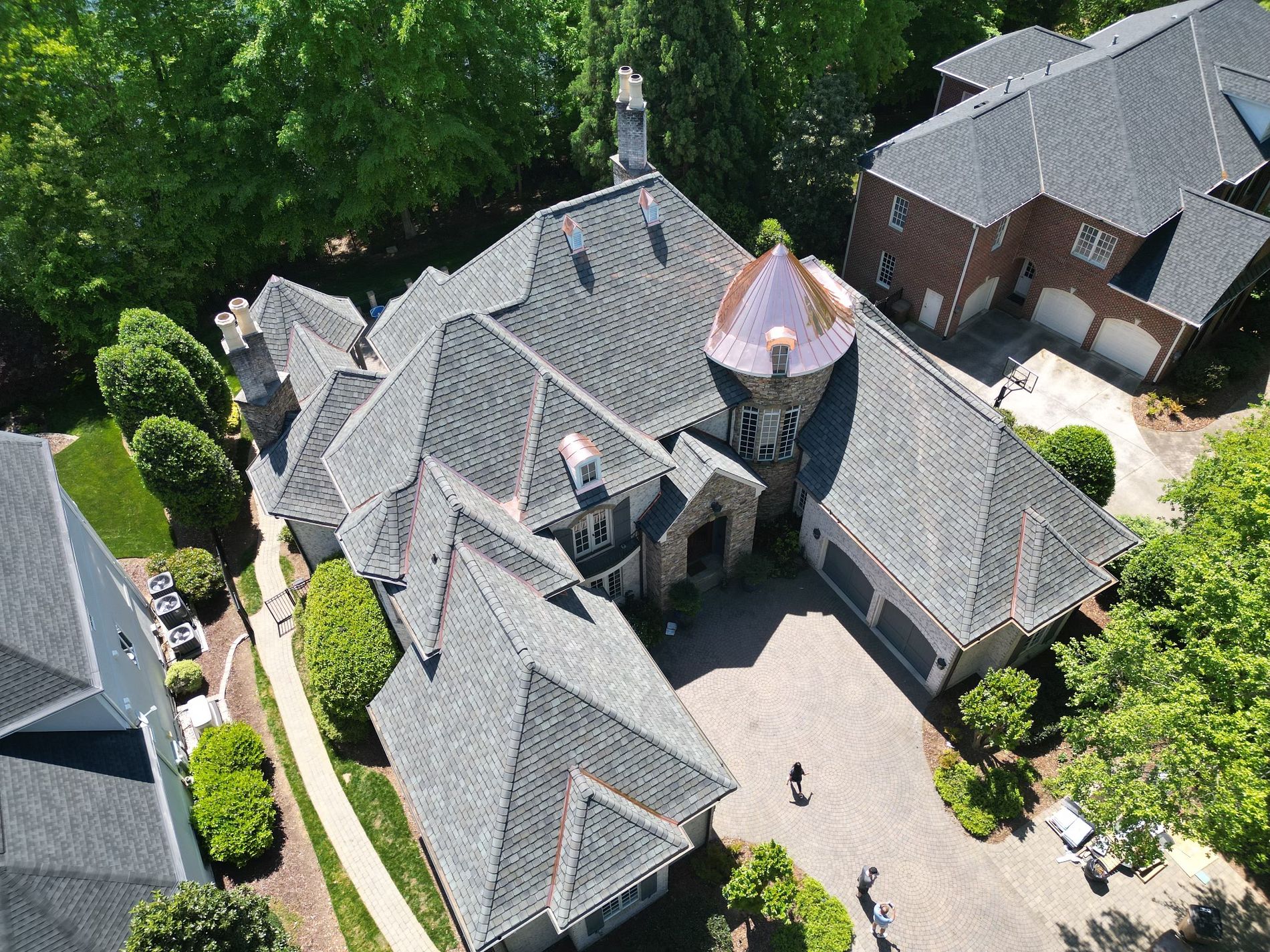 Aerial view of a slate-look shingle roof with a copper turret, copper dormers and copper valleys