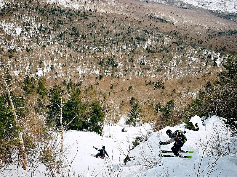 Backcountry skiers descending a steep snowy slope on Big Jay