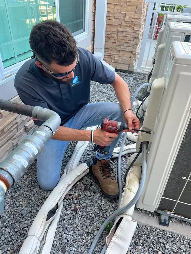 Technician servicing a mini split condenser