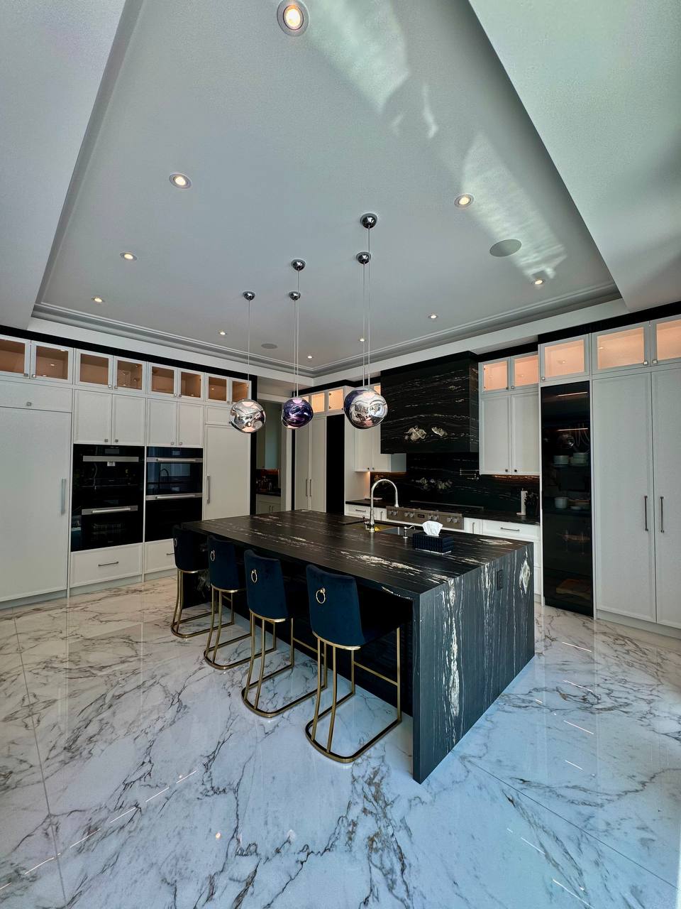 Luxury kitchen with dark marble island and pendant lighting