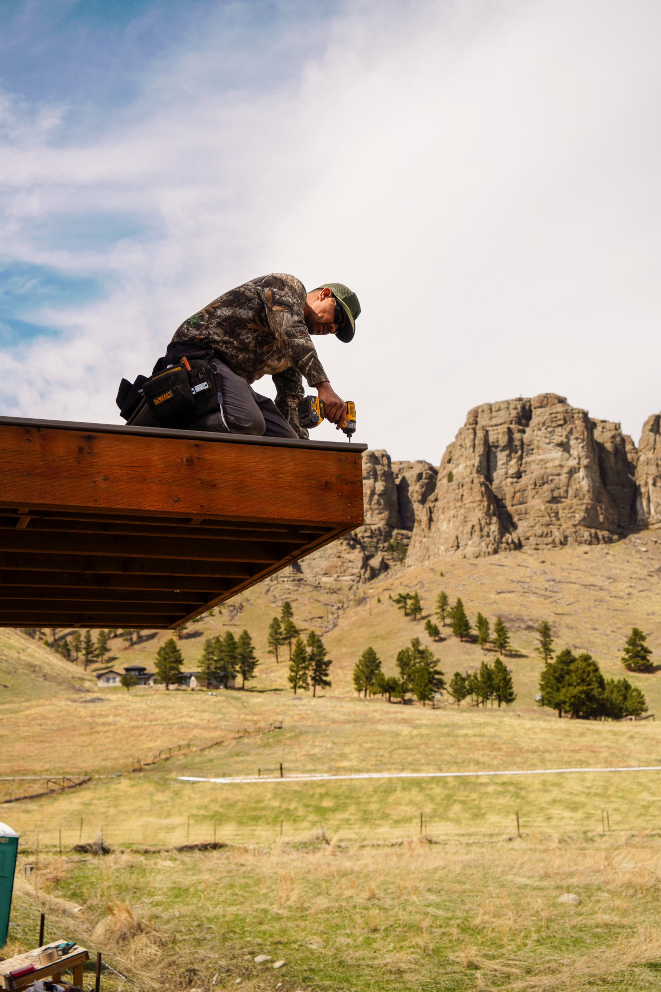 A carpenter building a deck under the Montana rims