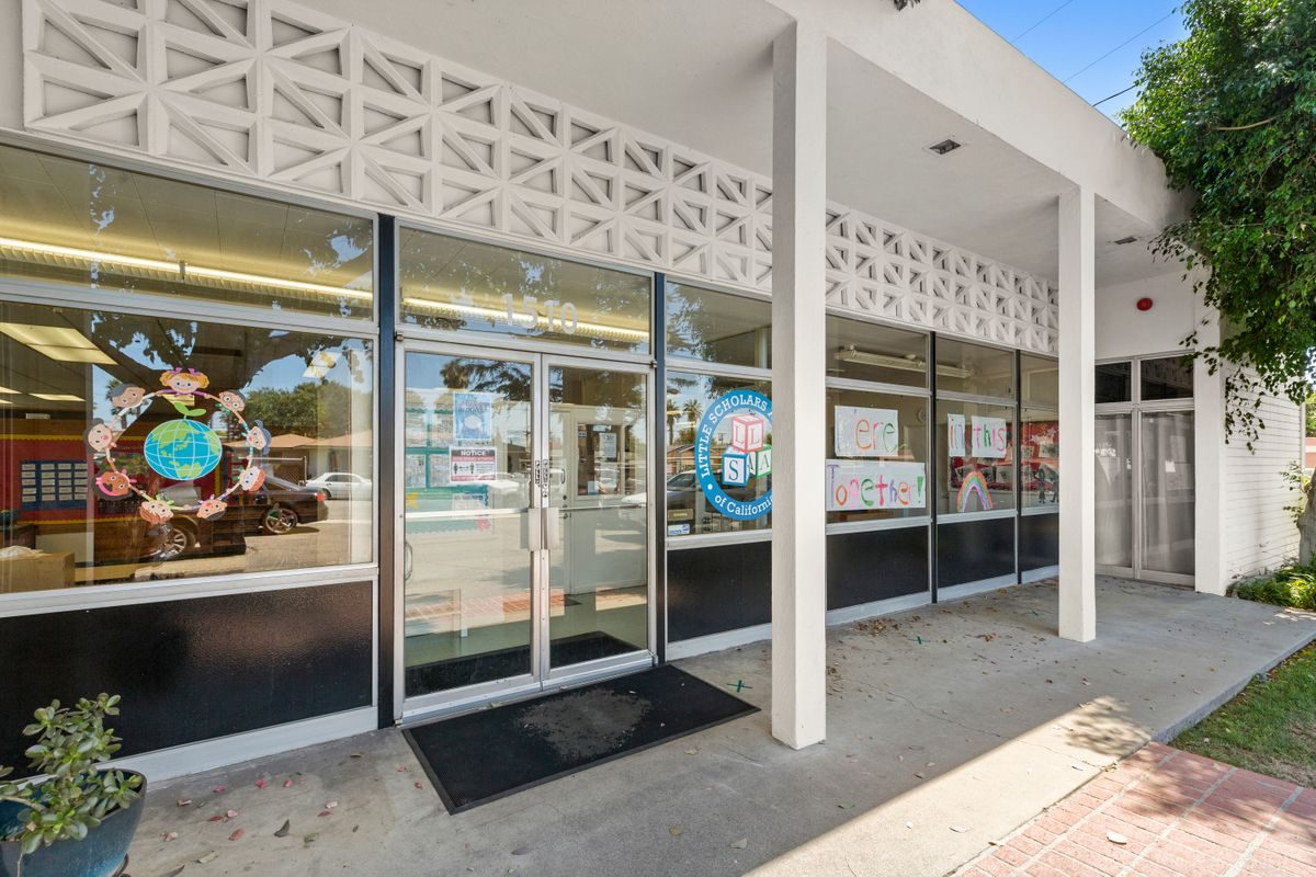 The front entrance of Little Scholars Academy on West Almond Avenue, with children's artwork in the windows