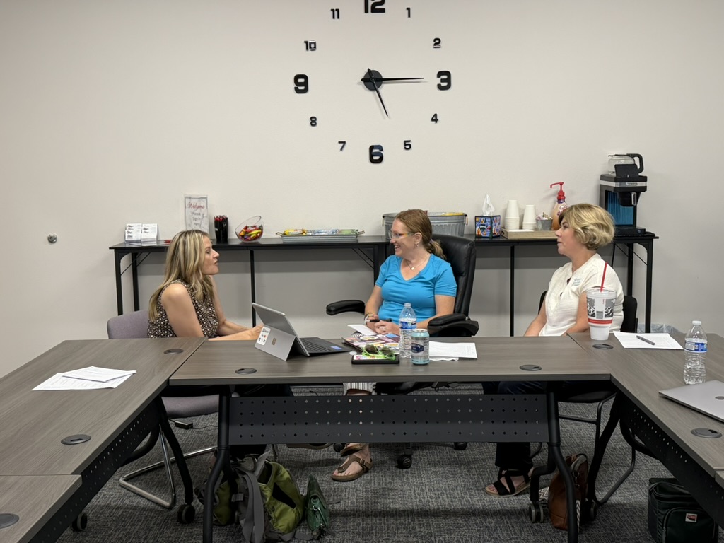 Three participants in conversation around a table at a Mattering in Motion gathering