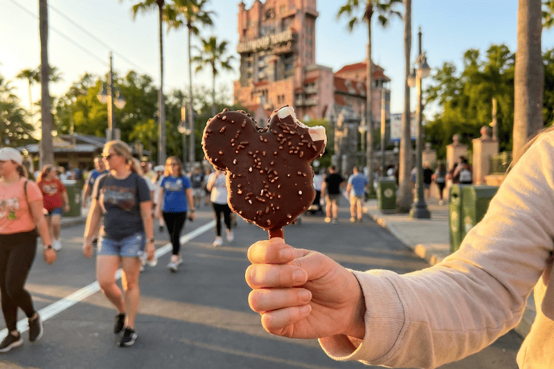 Disney themed snack in the foreground with people walking at sunset Disney themed snack in the foreground with people walking at sunset