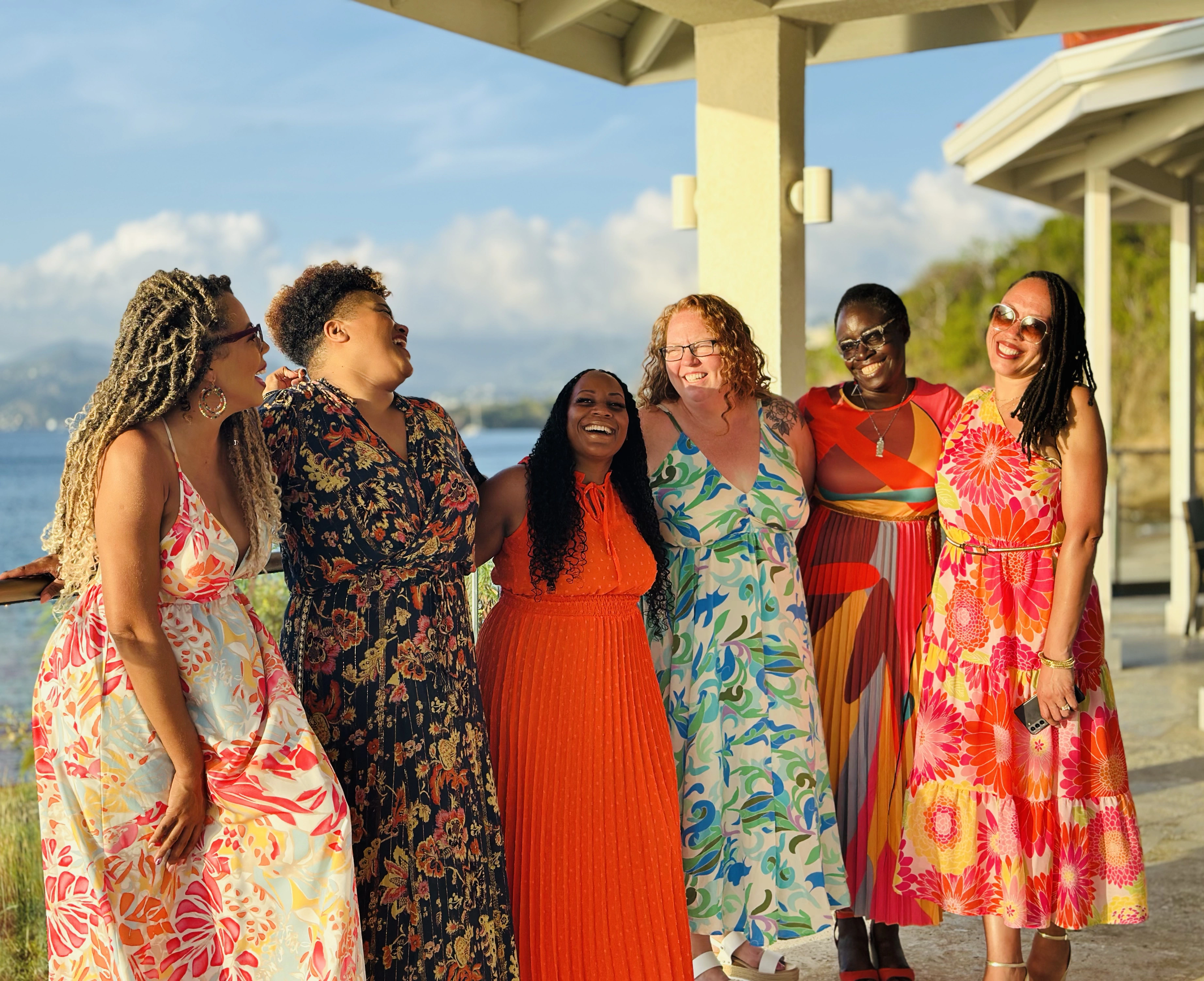 group of women laughing in colorful dresses at luxury retreat