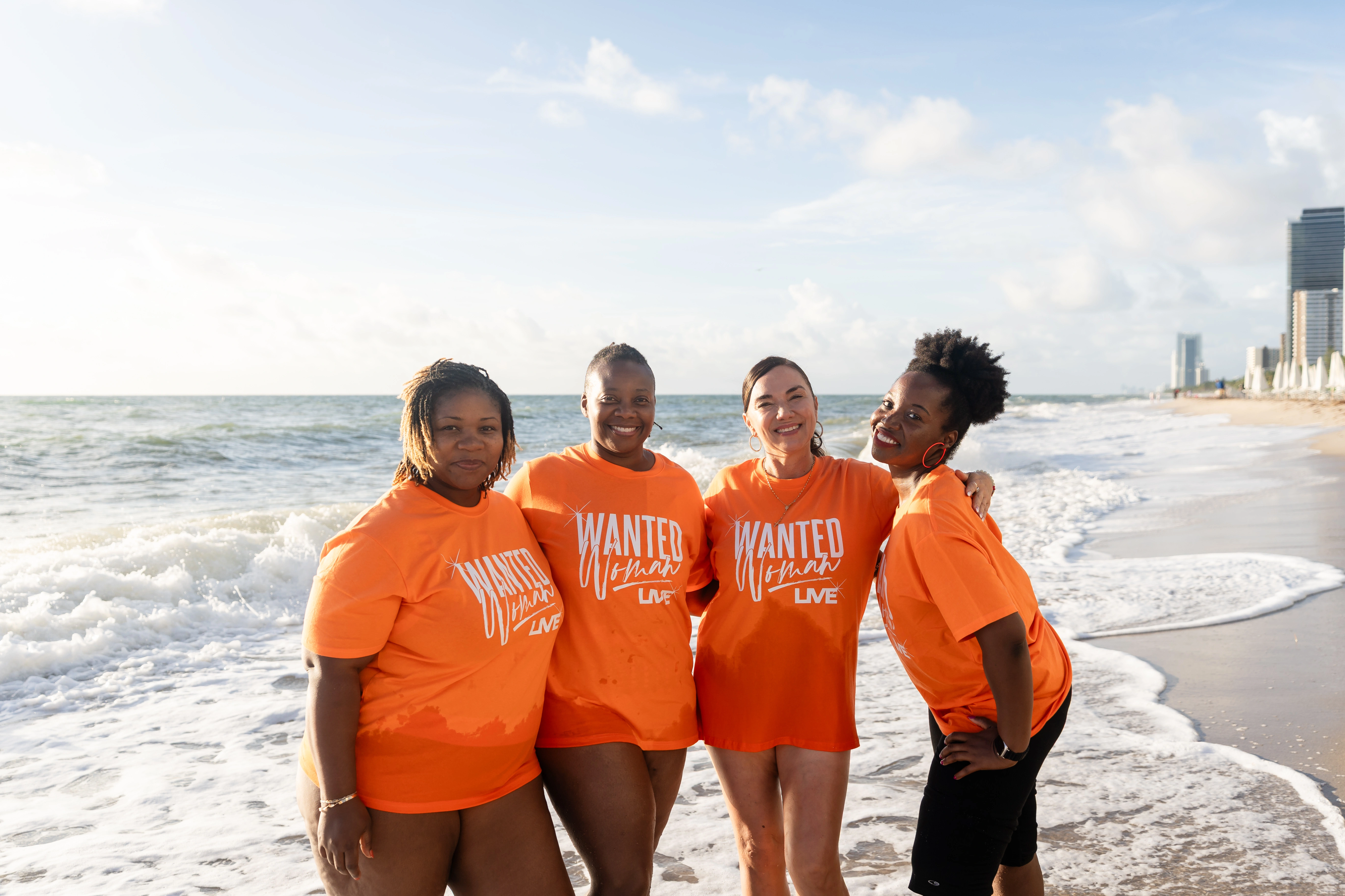 group of Black women smiling on beach at WANTED Woman Live
