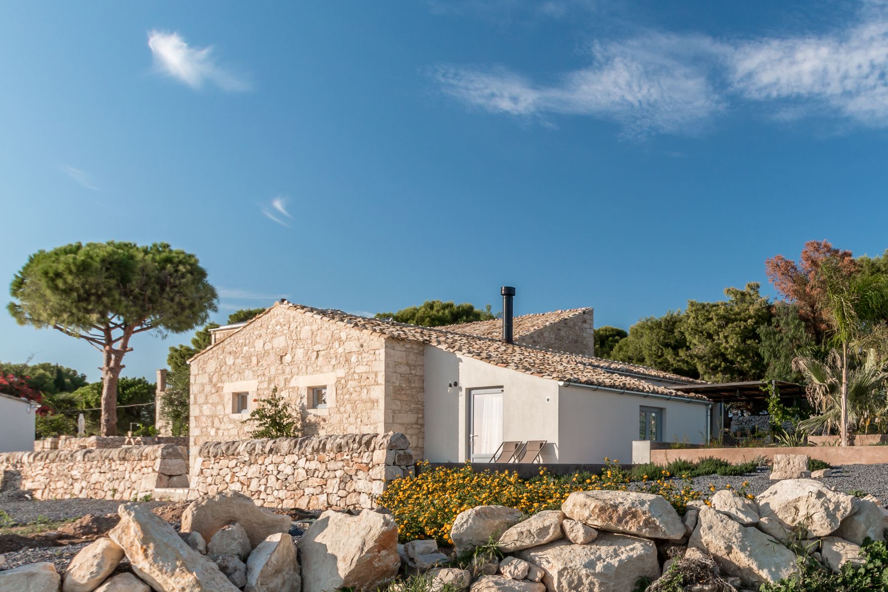 The 1800s stone farmhouse under umbrella pines