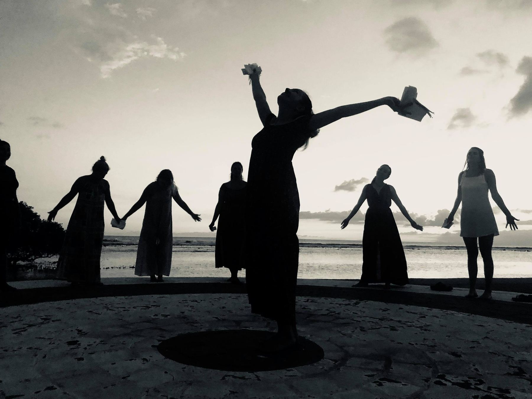 A release ritual in silhouette by the sea at dusk