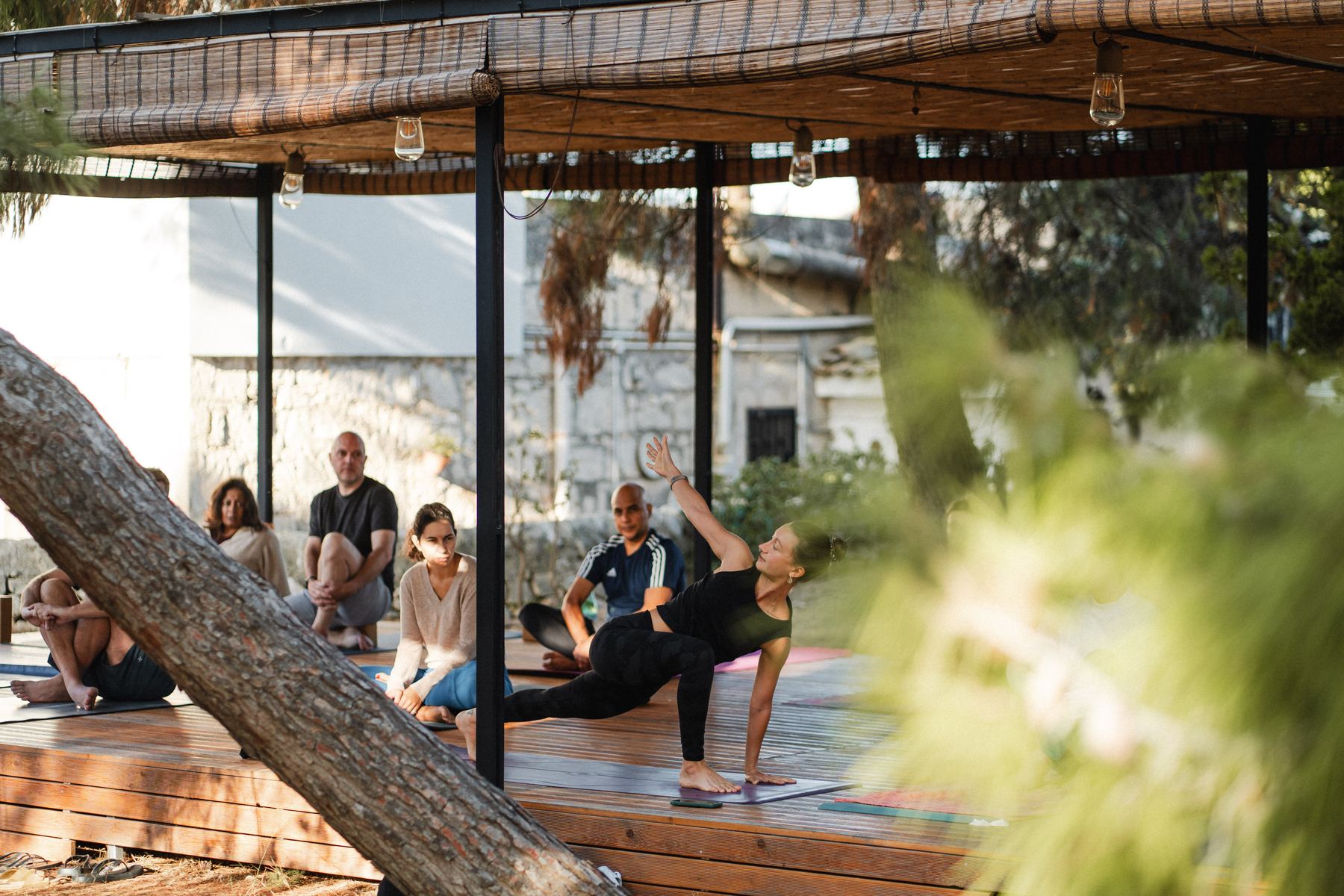 A teacher guiding a yoga class in the shala