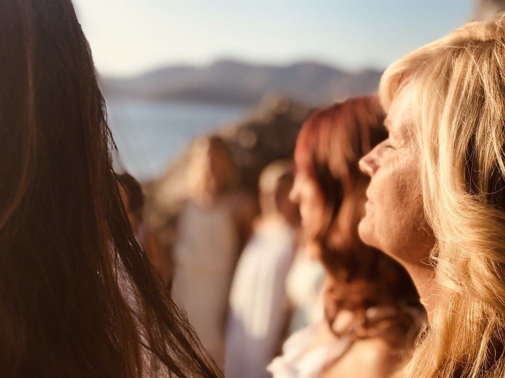 Faces turned to the sun at golden hour by the sea