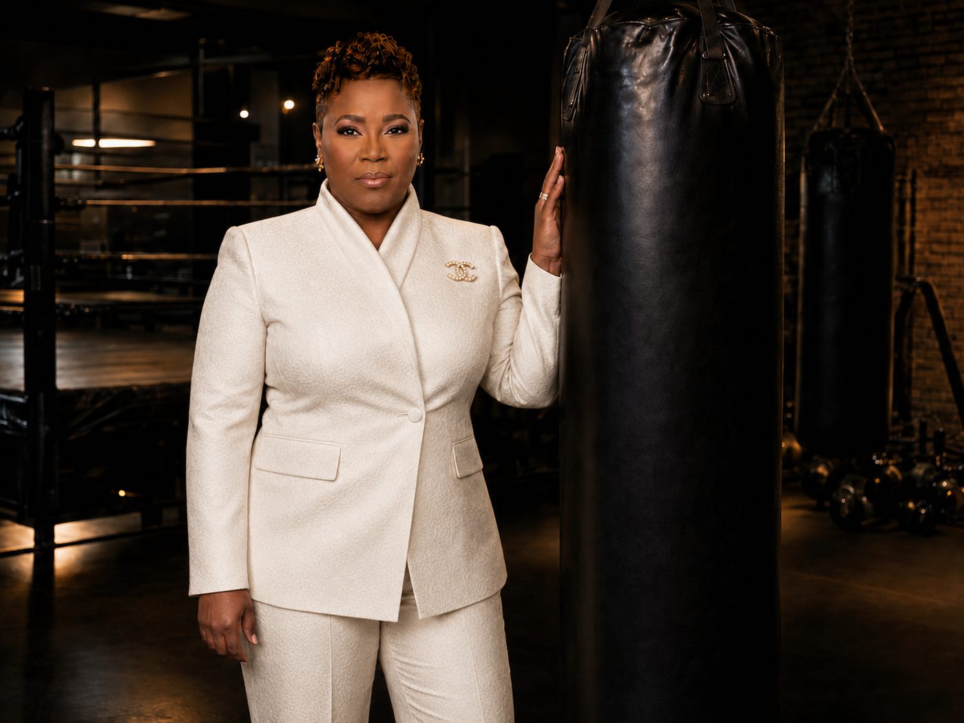 Mary H. Davis full-length in white suit next to boxing bag