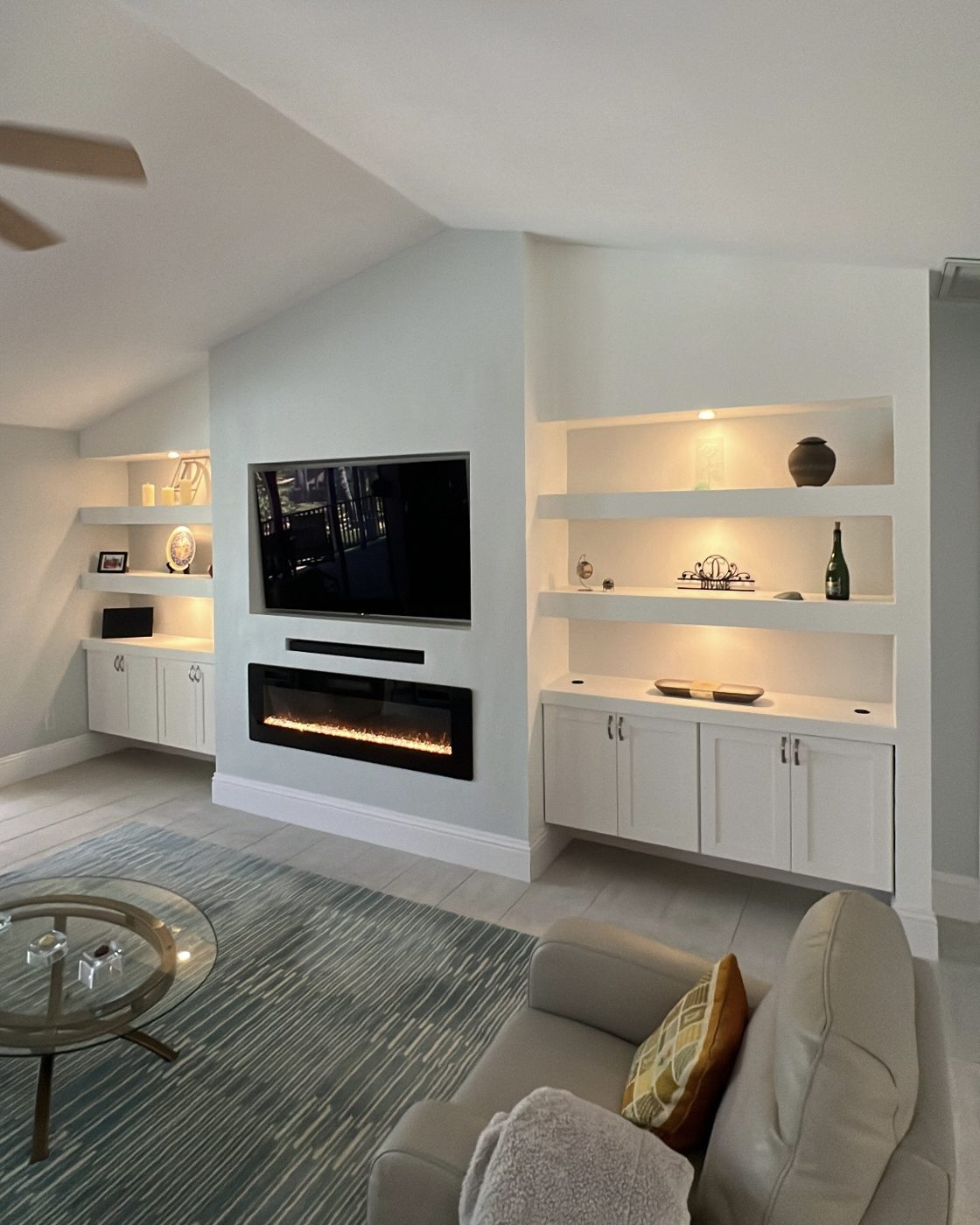 Coffered ceiling above custom built-ins and a linear fireplace in a Southwest Florida living room