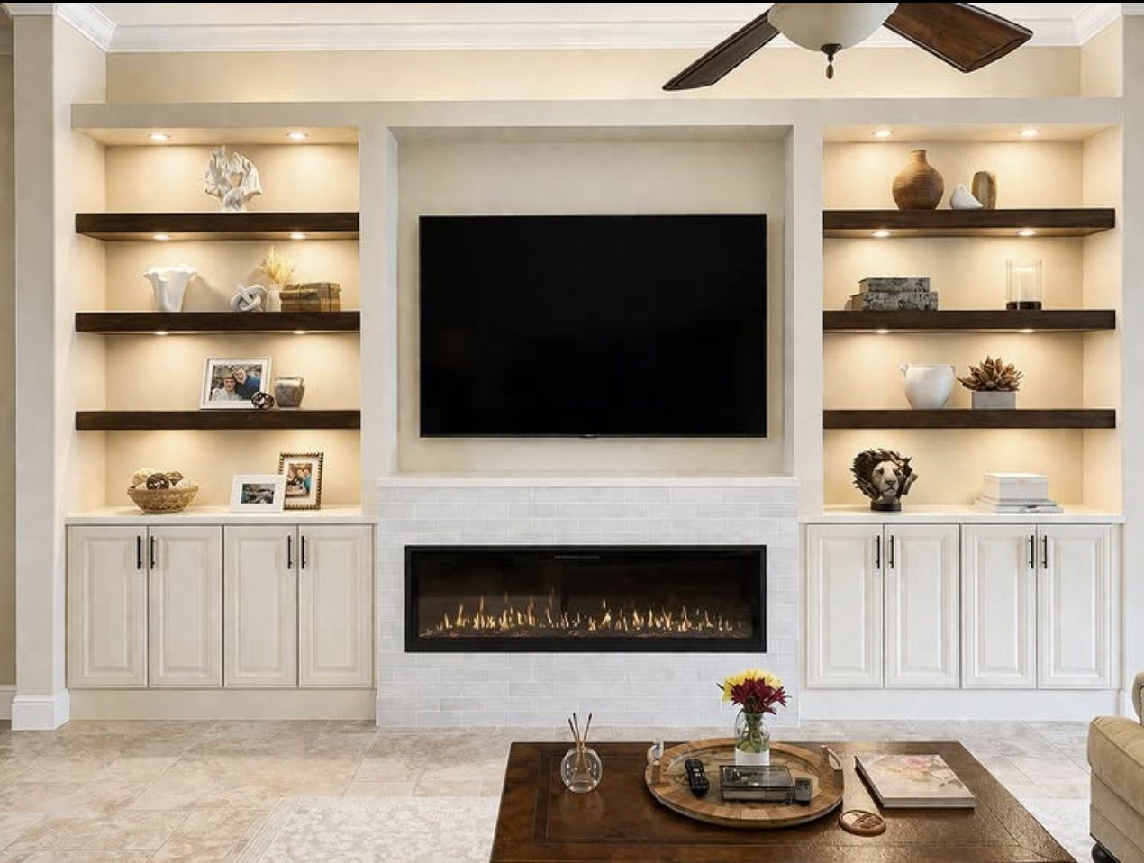 Custom built-in shelving and cabinetry flanking a linear fireplace with integrated lighting