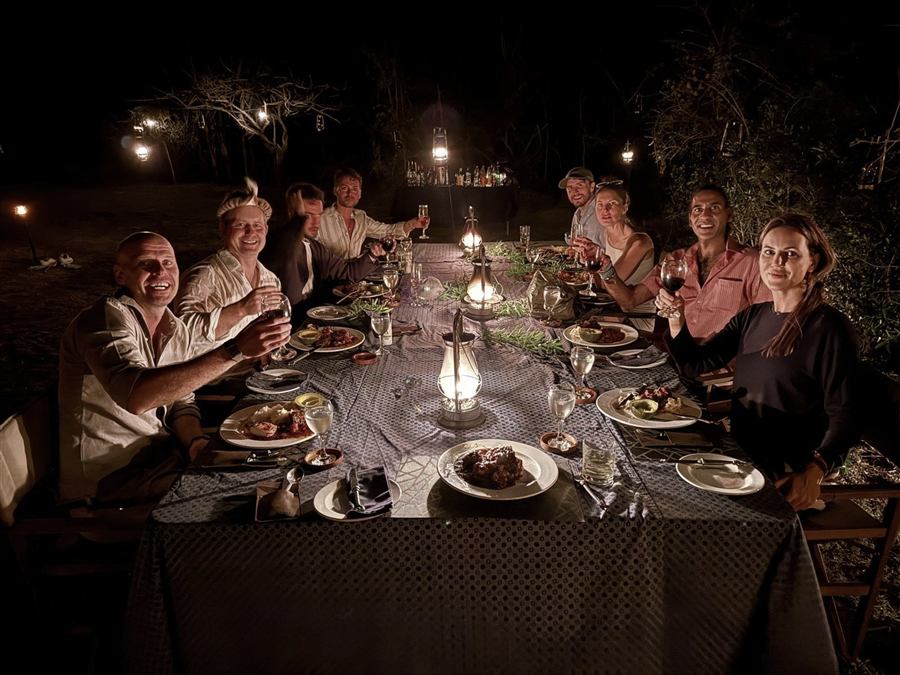 Members at a candlelit dinner on safari