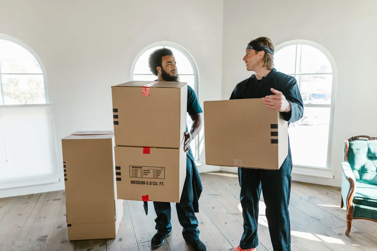 Two professional movers carrying boxes