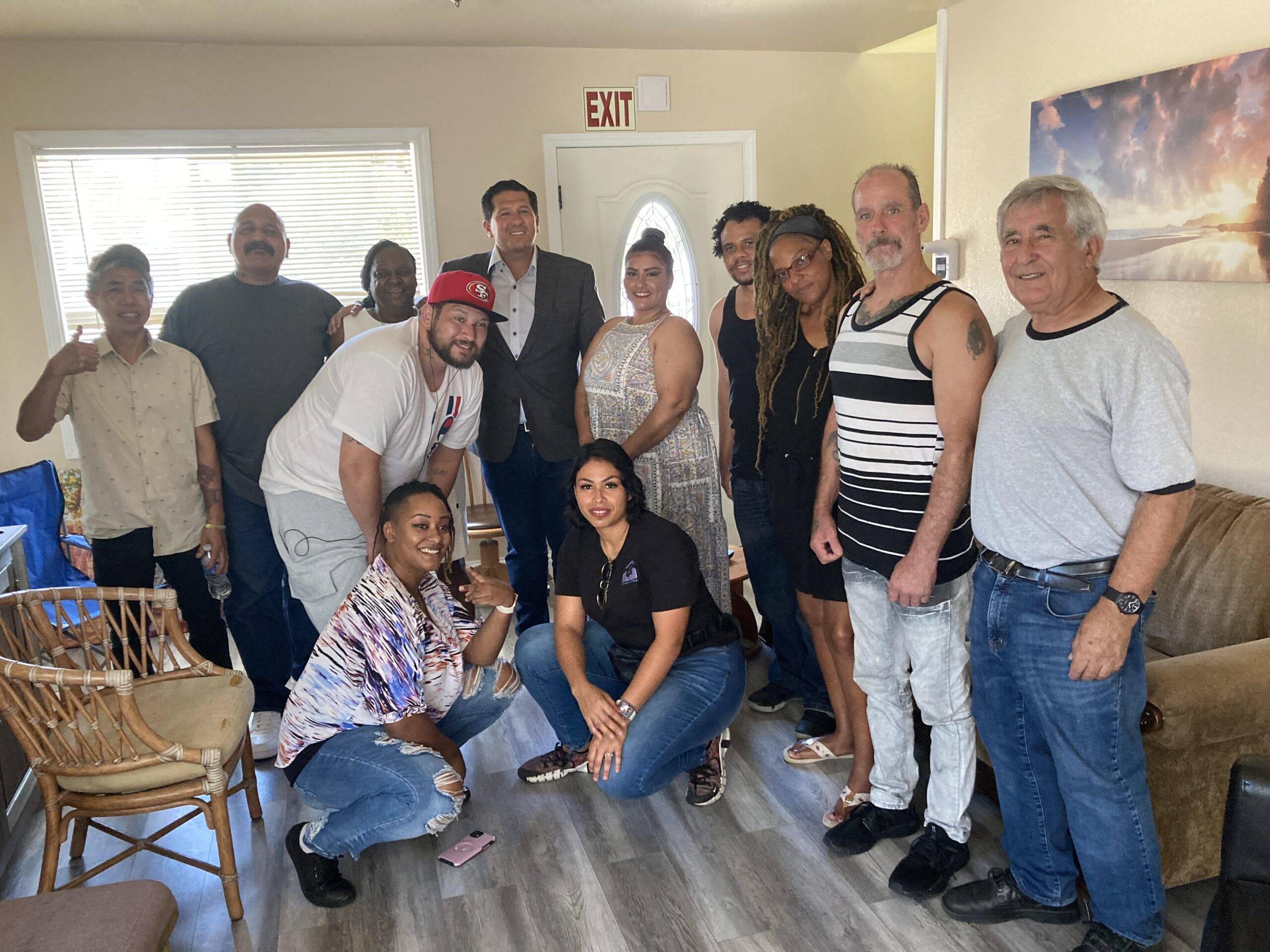 Group of people celebrating the opening of a new residential treatment home ran by Retraining The Village nonprofit in East Palo Alto California Group of people celebrating the opening of a new residential treatment home ran by Retraining The Village nonprofit in East Palo Alto California