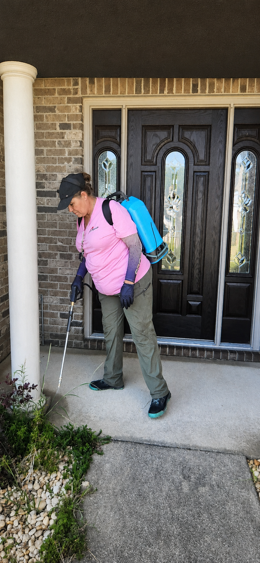 Pest control technician inspecting the exterior of a home in Central Alabama