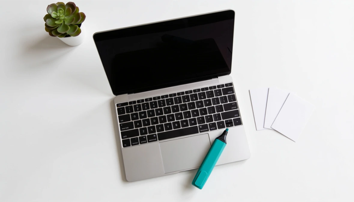 Overhead flatlay of blank cards and teal pen on light wood desk - comparing Kartra alternatives for coaches